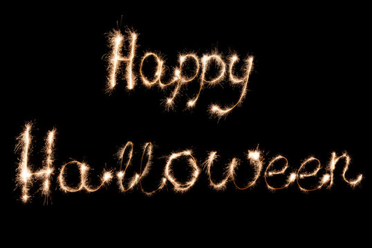 Inscription Sparklers Happy Halloween on a dark background.