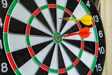 Dart arrows hitting in the target center of dartboard