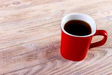 Cup of coffee on wooden table, top view