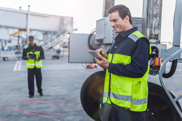 Happy male worker looking at digital device