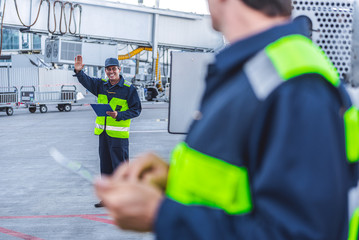Beaming man waving hand at airport