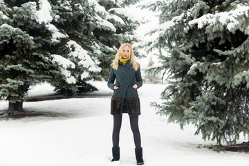 Model warming hands in coat pockets