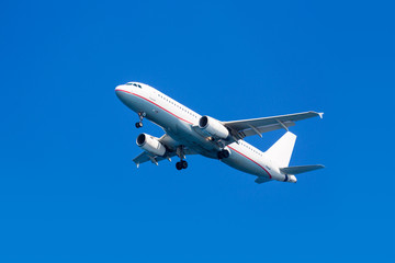 Fototapeta premium White airplane on a blue background,