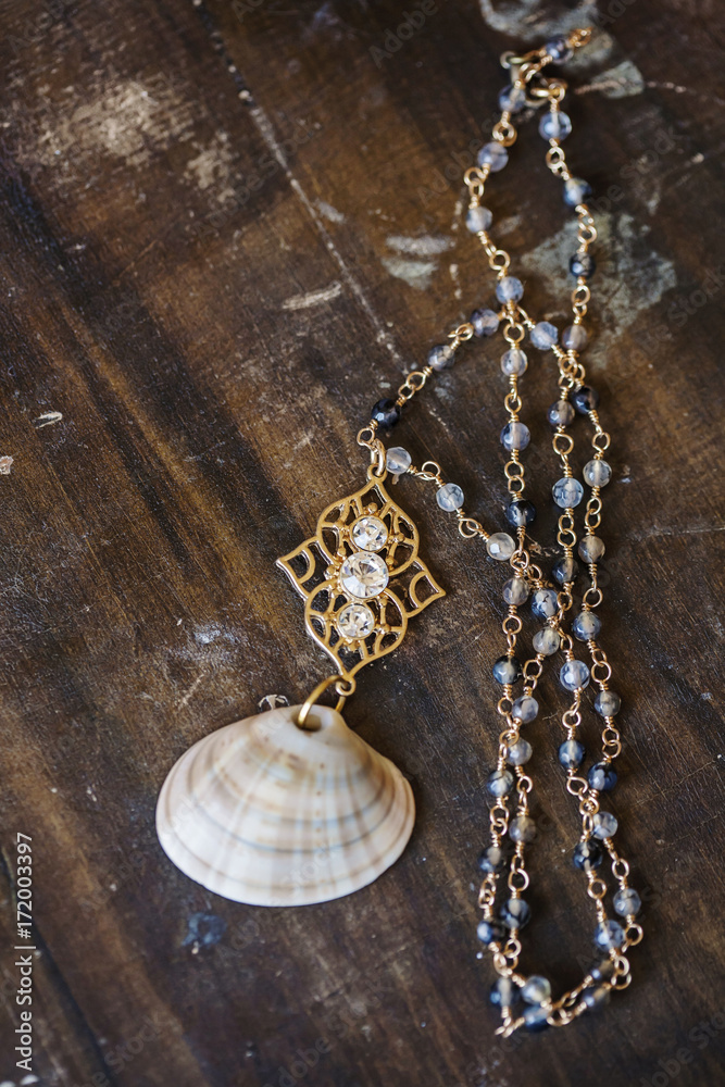 Wall mural Beautiful romantic necklace on the wooden table