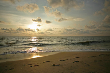 Golden sunset scene frames footprints on Alleppey Beach, Kerala, India