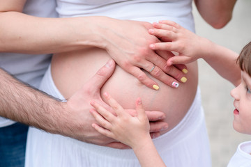 Fototapeta na wymiar The hands of the family at pregnant.
