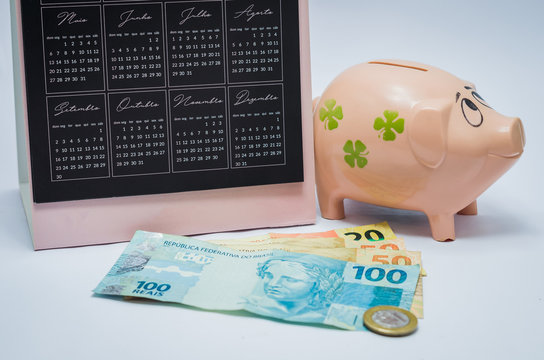 &Oacute;timo conceito de poupan&ccedil;a, economia, finan&ccedil;as, cofre de porqueinho (piggy bank), calend&aacute;rio e notas de real brasileiro.