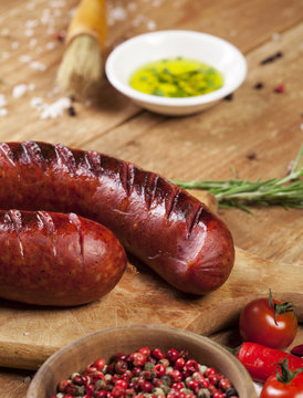 Grilled sausages on wooden background