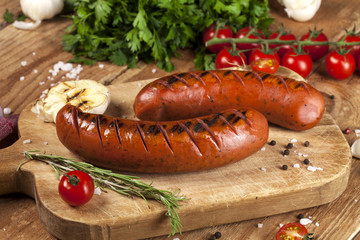 Grilled sausages on wooden background