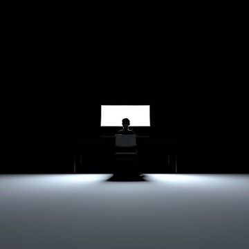 Person sitzt vor Bildschirm in dunklem Raum allein und depressiv und ist im Internet
