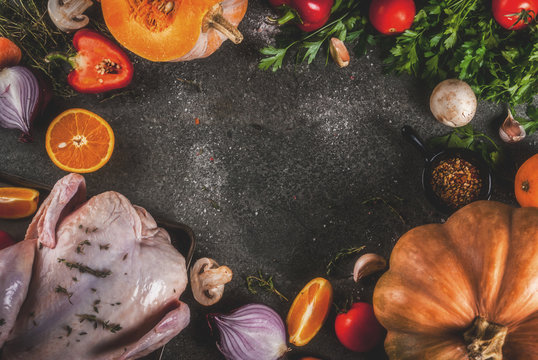 Cooking dinner for christmas, Thanksgiving. Traditional autumn ingredients are vegetables, pumpkin, mushrooms, chicken or turkey, fresh herbs, spices. On a dark table, Top view copy space, frame