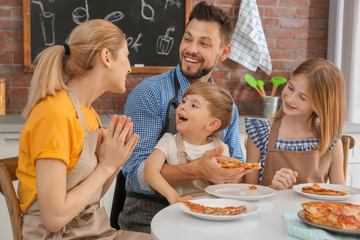 Family eating yummy pizza together in kitchen. Cooking classes concept