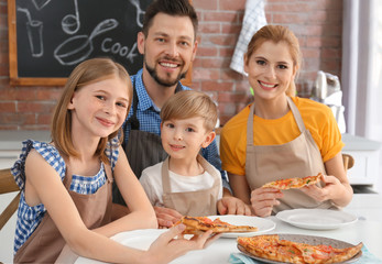 Family eating yummy pizza together in kitchen. Cooking classes concept