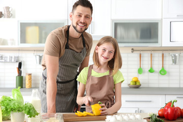 Father and daughter making meal together in kitchen. Cooking classes concept