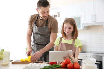 Father and daughter making meal together in kitchen. Cooking classes concept