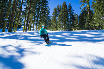 Mixed race woman on snowboard rides quickly through snow in the mountains