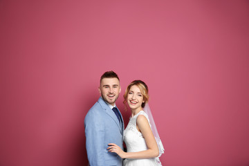Fototapeta premium Happy wedding couple on color background
