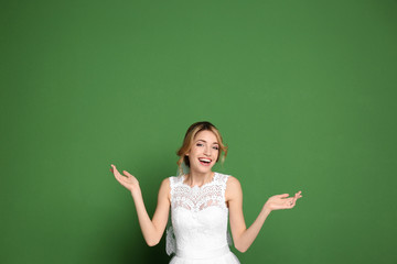 Young beautiful bride on color background