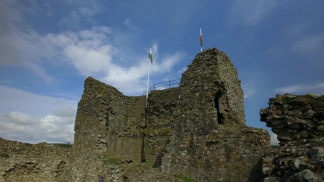 Welsh stone castle panning view with hanging flags.