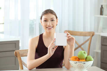 Beautiful young woman with biologically active supplement sitting at table. Diet concept