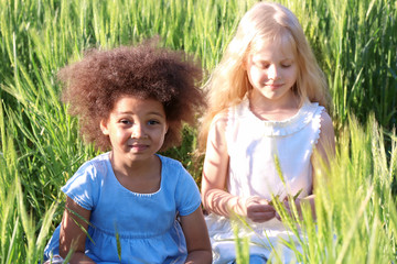 Happy little girls in green field