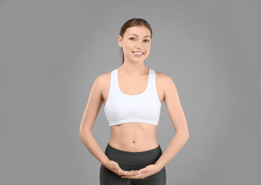 Beautiful young woman on gray background. Diet concept