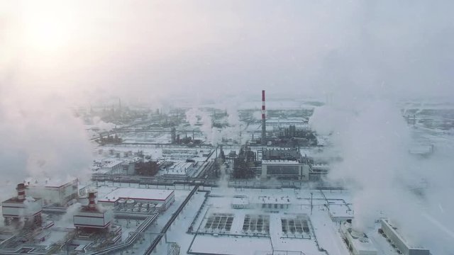 Storm weather and snowfall. Aerial view of gas processing plant at winter time. Cold morning at industrial zone
