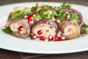 Traditional vegan badrijani from Georgia - fried eggplant rolls with walnut-garlic filling and decorated with pomegranate seeds and parsley