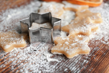 Raw cookies sprinkled with flour on wooden board