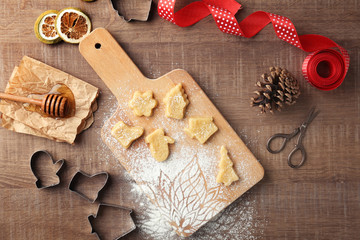 Fototapeta na wymiar Christmas composition with raw cookies and cutters on wooden table
