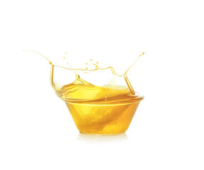 Cooking oil splashing from bowl, isolated on white