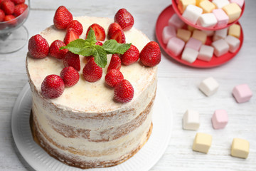 Delicious strawberry cake on wooden table