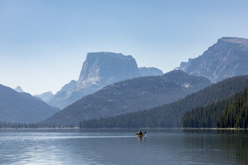 Fototapeta na wymiar kayaker paddling out on a beautiful mountain lake