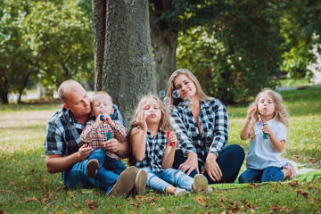 Fototapeta premium Young family with cheerful children in the park