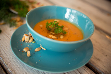 Squash soup served with parsley and pumpkin seeds / Autumn concept