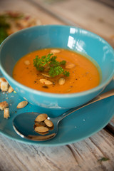 Squash soup served with parsley and pumpkin seeds / Autumn concept