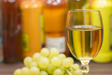 A glass of white wine and a bunch of grapes
