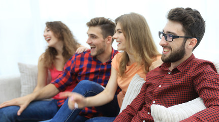 group of smiling young people sitting on the couch