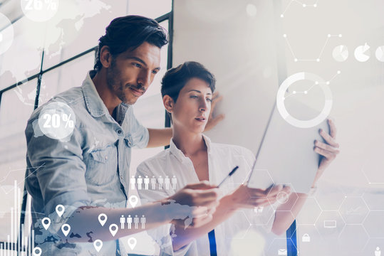 Concept of digital diagram,graph interfaces,virtual screen,connections icon on blurred background.Coworking team meeting.Two colleagues working with startup project in modern office.