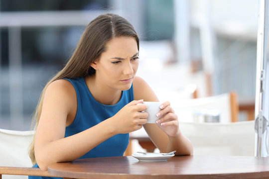 Angry woman thinking in a coffee shop terrace