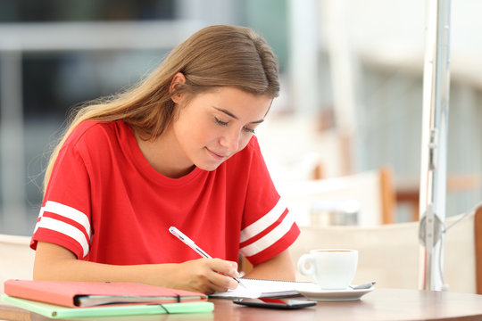 Serious Student Studying Taking Notes In A Bar