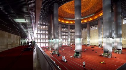 JAKARTA, Indonesia. September 14, 2017: Interior view footage of Istiqlal Mosque and muslim people praying on the first floor in Jakarta