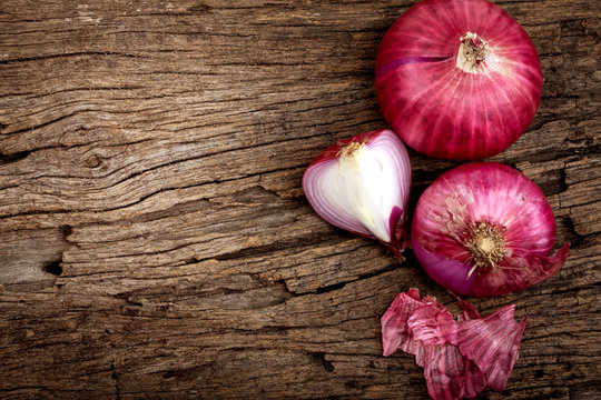 Close up of the  sliced red onion and whole bulb onion on a wooden background