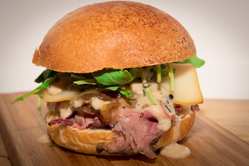 Smoked beef burger with smoked cheese, lettuce, caramelized onions and pepper sauce.