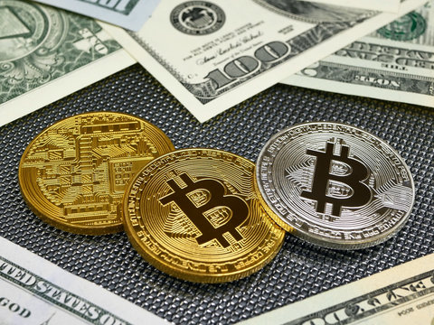Golden and silver bitcoin coins and american dollars notes on abstract background. Bitcoin cryptocurrency.