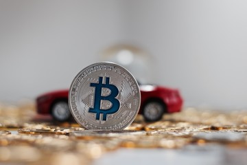 Bitcoin coin near red car