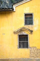 Fototapeta na wymiar The old wooden window on yellow ancient brick wall