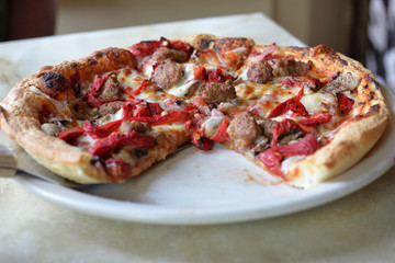 Sausage and pepper pizza on white plate