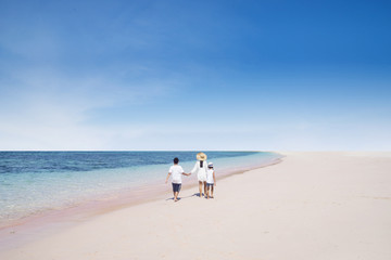 Mother with children walking on the beach