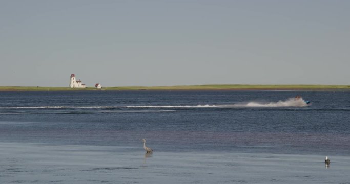 Sea doo speeds past scenic lighthouse view